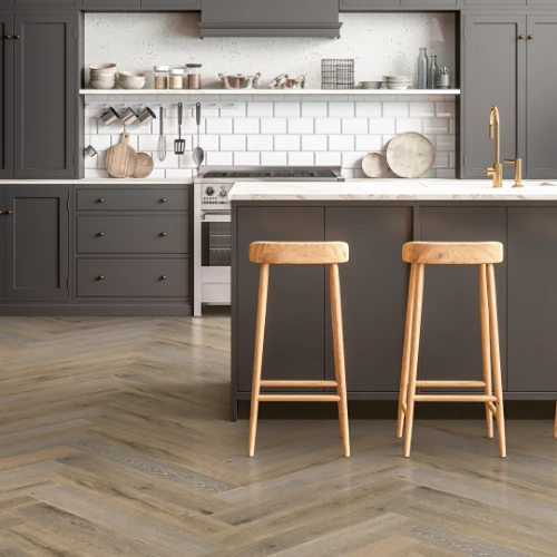 Herringbone flooring in kitchen with gray cabinets